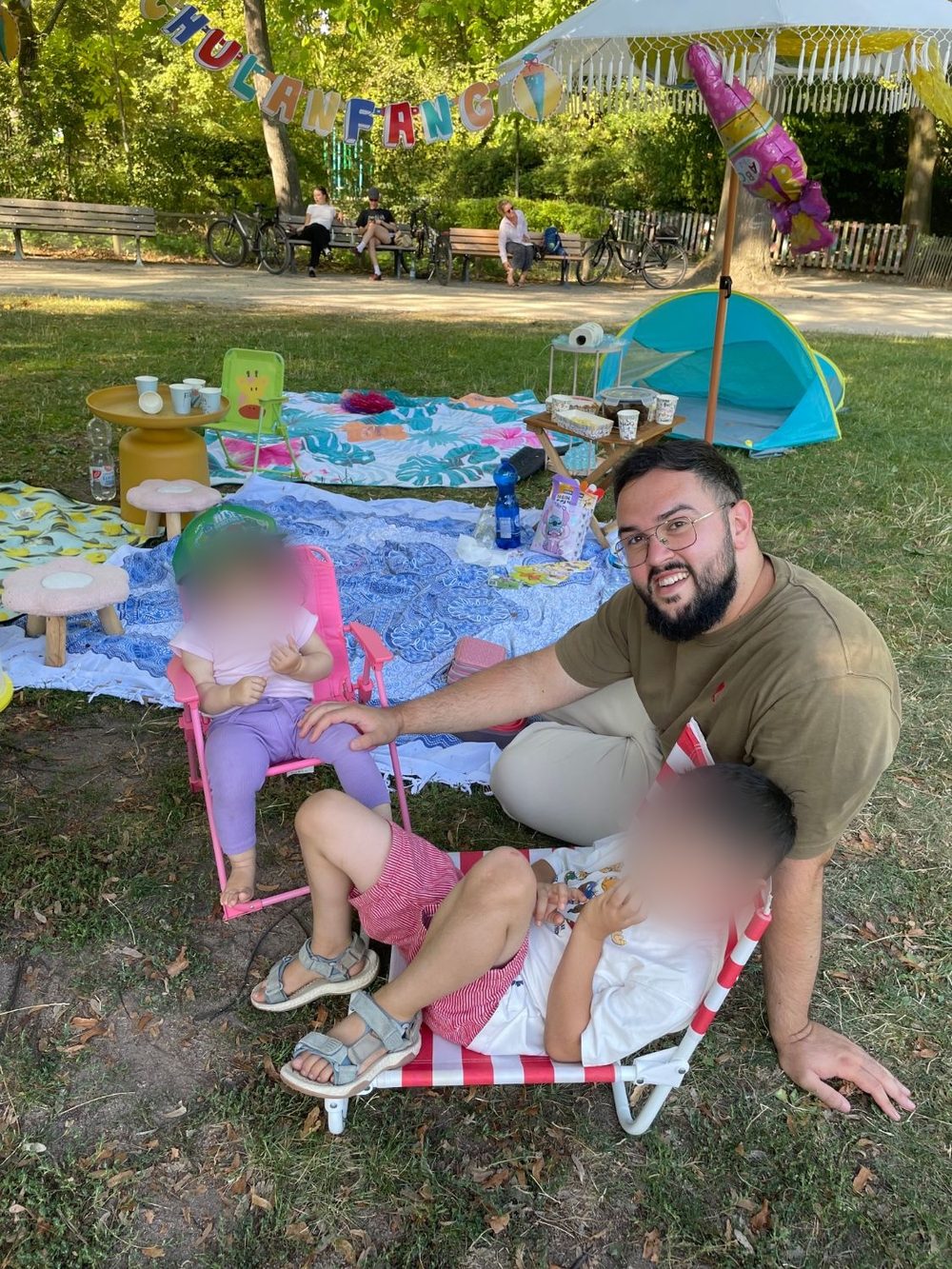 Muhammed bei einem Picknick mit seinen beiden Kindern, deren Gesichter unkenntlich gemacht sind